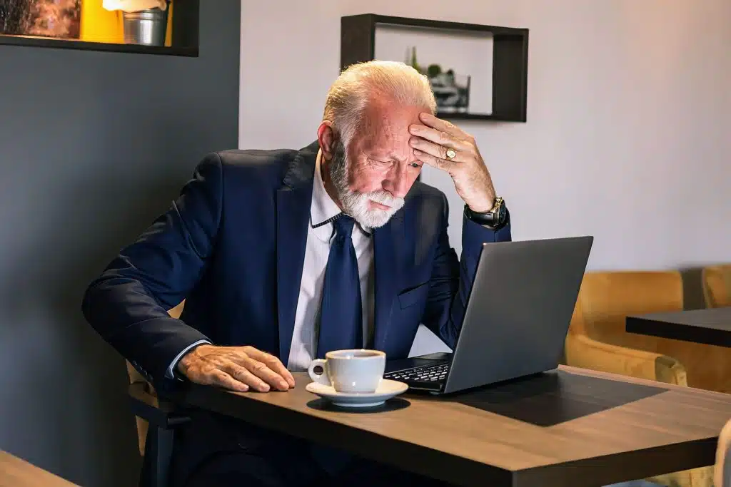 A concerned man looks at his computer.